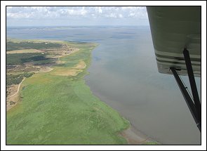 Piper L4-H OY-DHN over Albuebugten med Hansodde som pynt