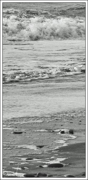 Bølger ruller ind på stranden
